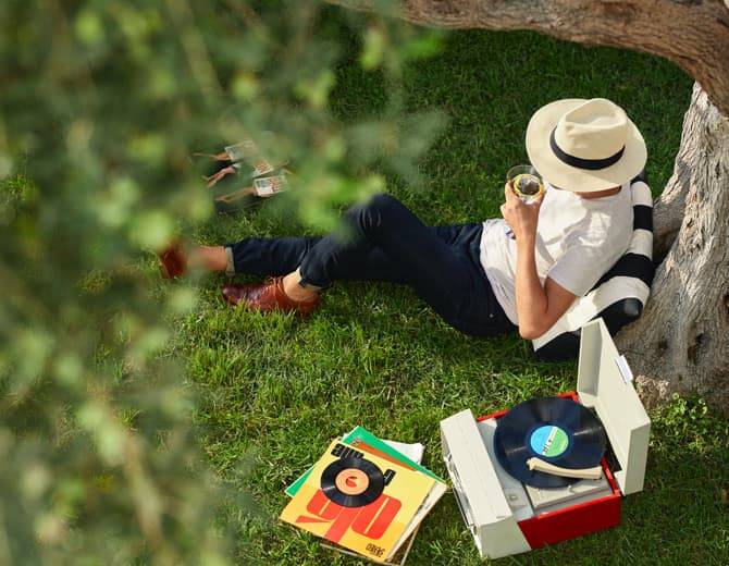 person sitting under a tree drinking a cocktail